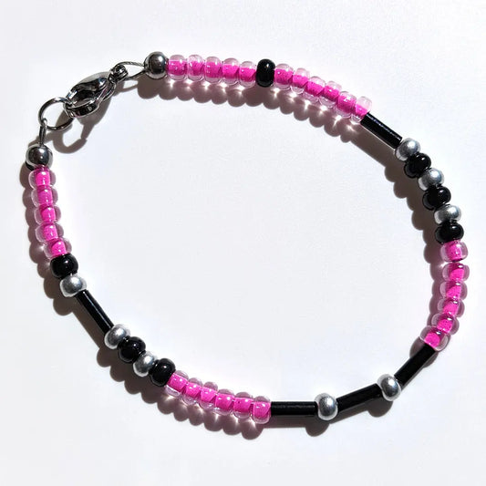 Playful Bubblegum Shimmer Morse code bracelet, handcrafted with fun and flirty pink & silver Czech glass beads, holds the secret message “Love.”
