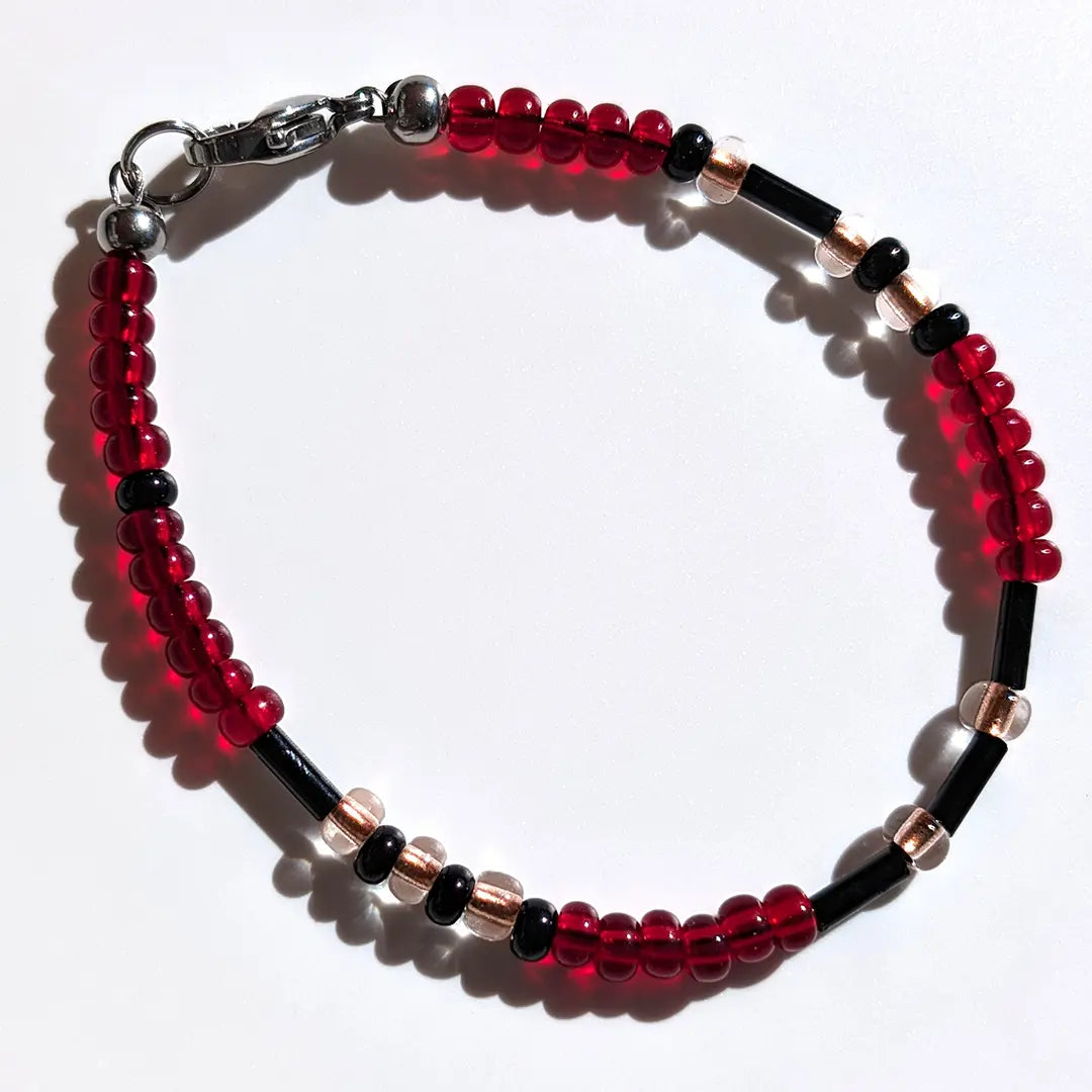 Elegant Cherry Sparkle Morse code bracelet, handcrafted with bold, passionate red & clear gold Czech glass beads, holds the secret message “Love.”