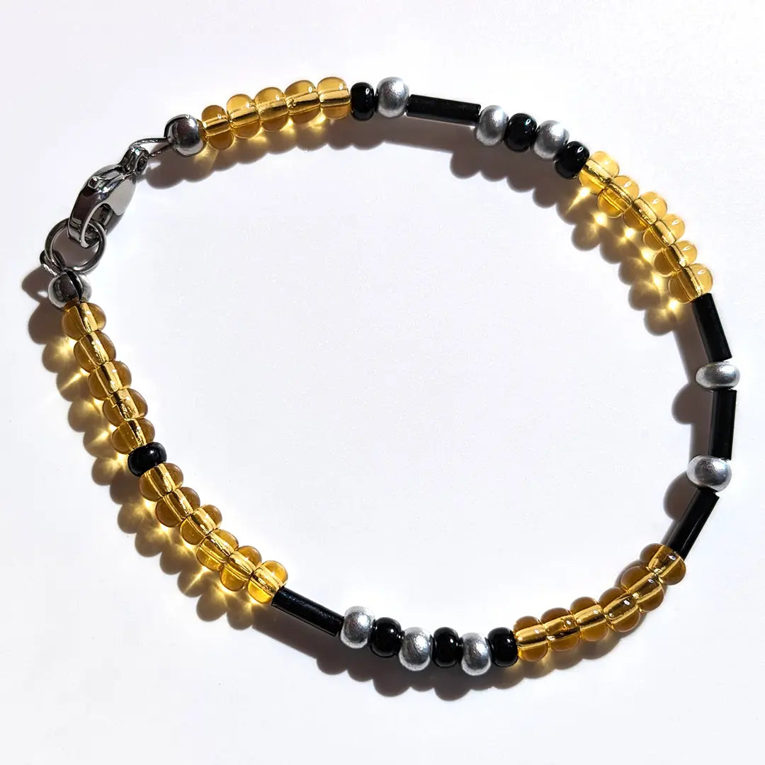 Vibrant Lemonade Shimmer Morse code bracelet, handcrafted with bright, lively yellow & silver Czech glass beads, holds the secret message “Love.”