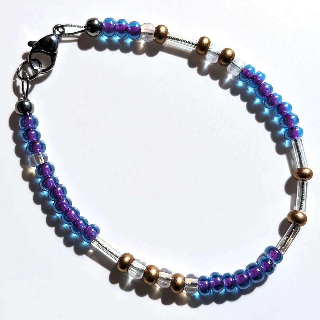Sophisticated Smoothie Glitter Morse code bracelet, handcrafted with luxurious blue-purple & gold Czech glass beads, holds the secret message “Love.”