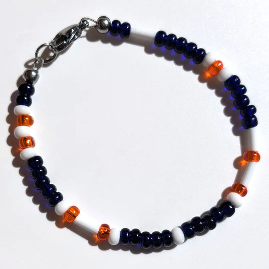 Cheer on the Detroit Tigers with this Morse code bracelet, handcrafted with 100% stainless steel coupled with white, orange, and dark blue glass beads.