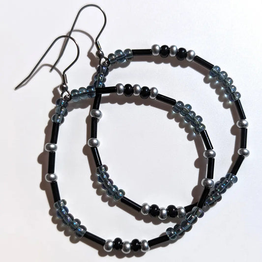 Enchanting Oil Slick Shimmer Morse code earrings, handcrafted with ethereal iridescent gray & silver Czech glass beads, hold the secret message “XOXO.”