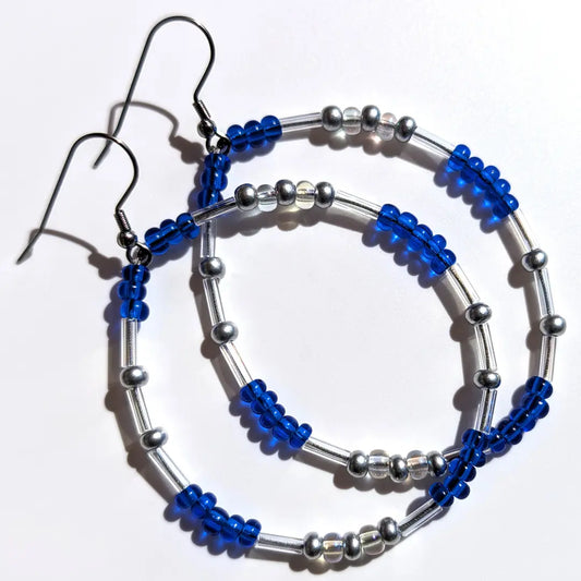 Serene Saffie Shimmer Morse code earrings, handcrafted with calming blue & silver Czech glass beads, hold the secret message “XOXO.”