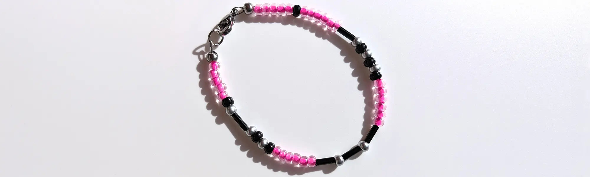 Playful Bubblegum Shimmer Morse code bracelet, handcrafted with fun and flirty pink & silver Czech glass beads, holds the secret message “Love.”