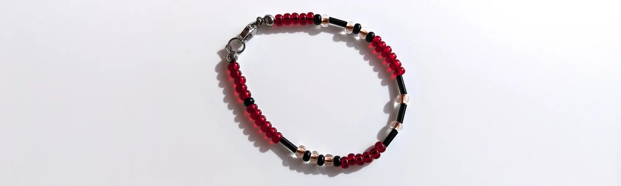 Elegant Cherry Sparkle Morse code bracelet, handcrafted with bold, passionate red & clear gold Czech glass beads, holds the secret message “Love.”