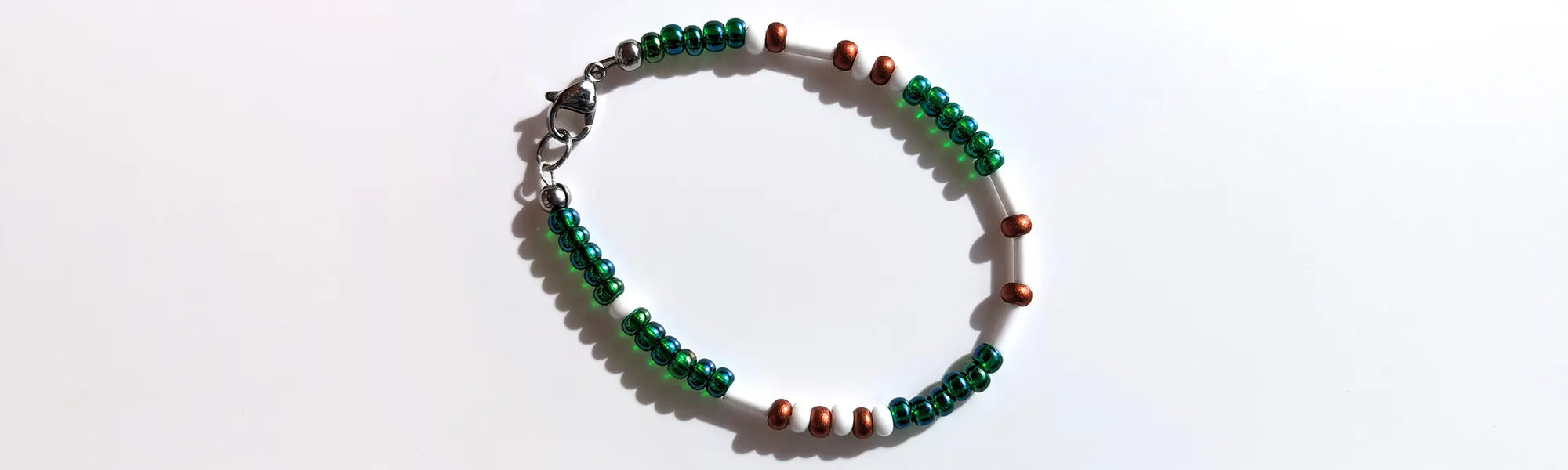 Mesmerizing Mermaid Luster Morse code bracelet, handcrafted with serene blue-green & copper Czech glass beads, holds the secret message “Love.”